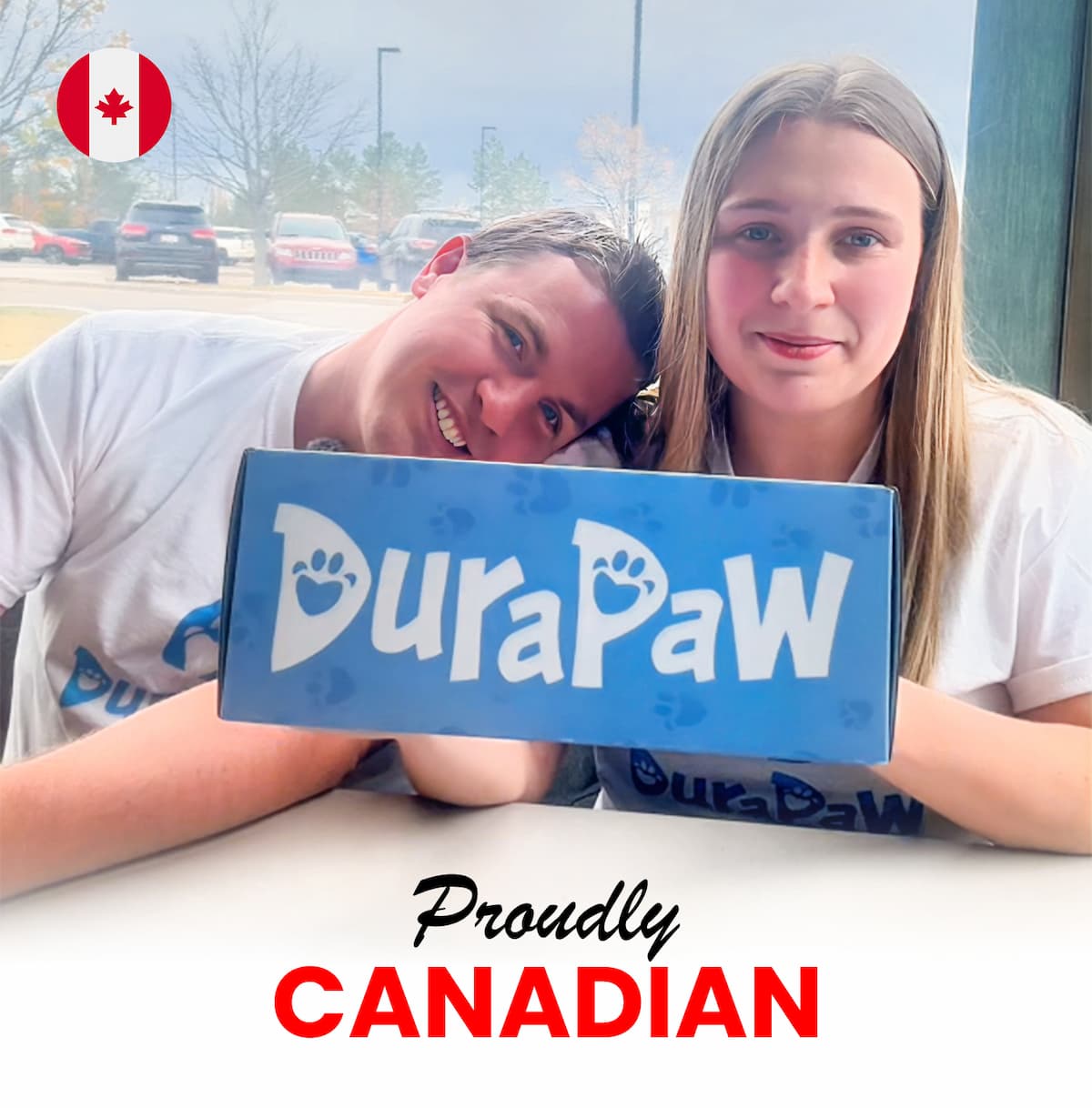 Marc and Bailey proudly holding a DuraPaw box in front of a Canadian flag, representing their Canadian-owned dog toy and treat subscription box